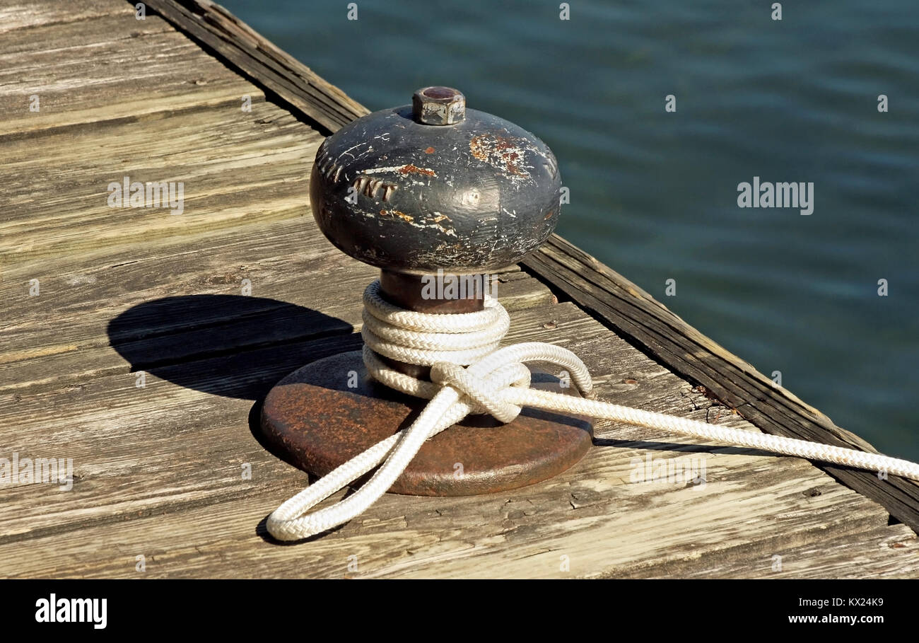 Rope tied to a metal boat slip at dock Stock Photo
