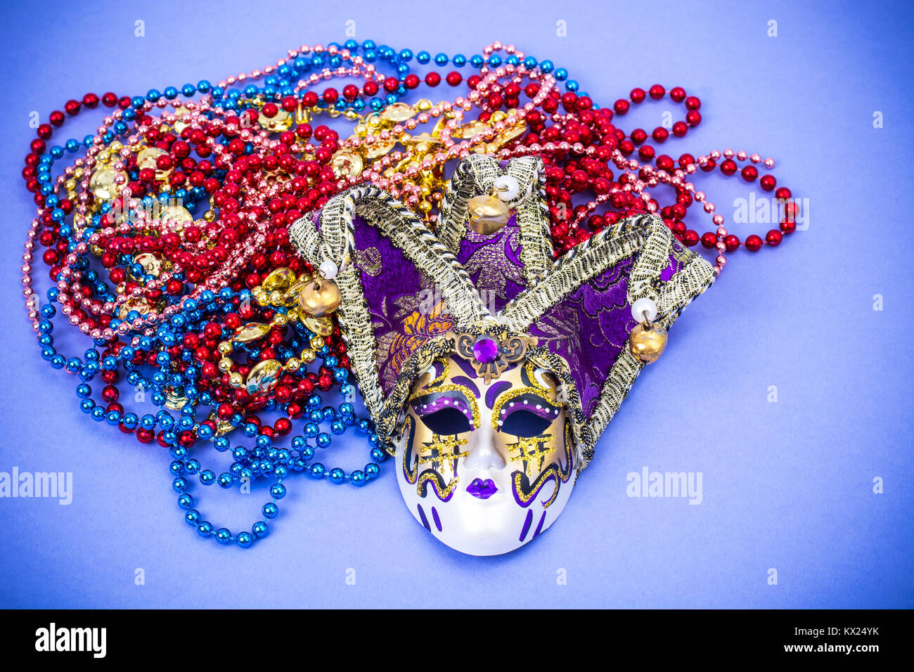 Festival Mardi Gras mask and multicolored beads on bright background