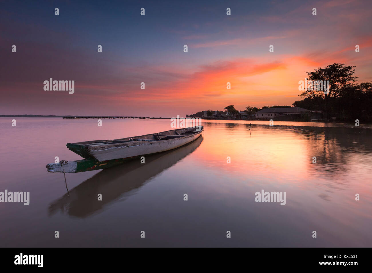 Landscape view of moored boat on calm river at sunrise, Tendaba Camp, The Gambia in November. Stock Photo