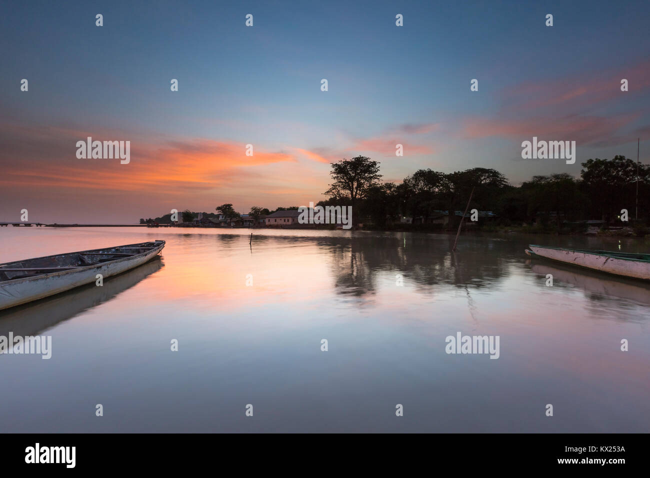 Landscape view of moored boat on calm river at sunrise, Tendaba Camp, The Gambia in November. Stock Photo
