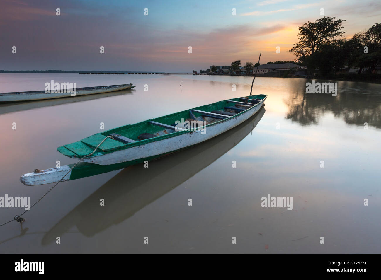 Landscape view of moored boat on calm river at sunrise, Tendaba Camp, The Gambia in November. Stock Photo