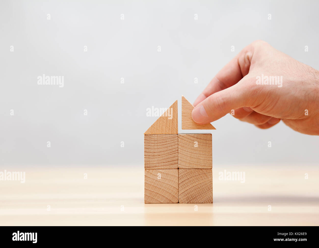 Hand building house with wooden blocks Stock Photo
