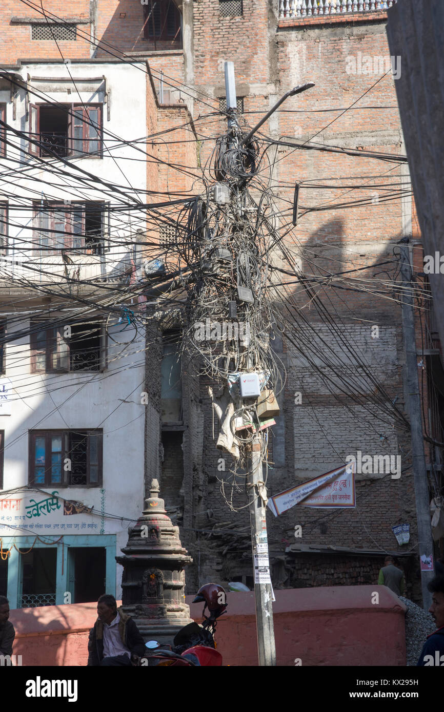 innumerable electric power and telephone lines are tangled together on a single utility pole