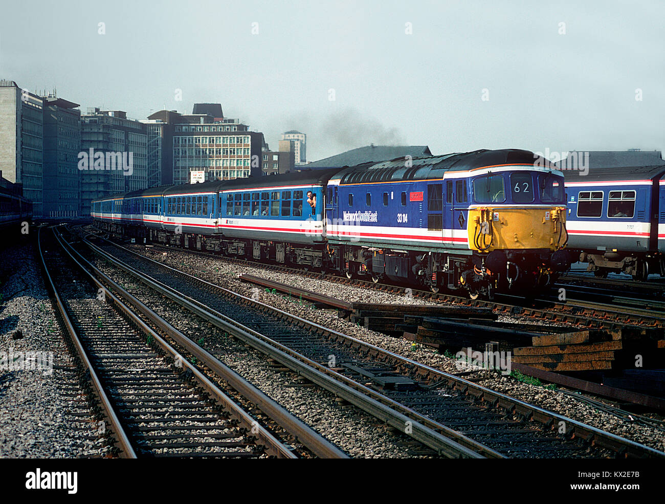 In May 1992 33114 was repainted into Network SouthEast colours and named "Ashford 150". The celebrity Crompton is seen working a "Network Express" service at Vauxhall. 29th July 1992. Stock Photo
