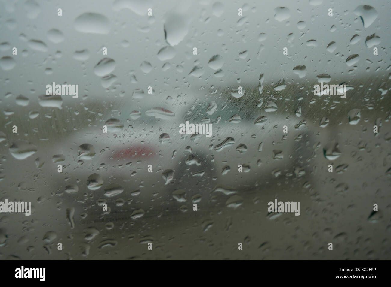 White car seen through a rain drops covered car glass, Normandy, France Stock Photo