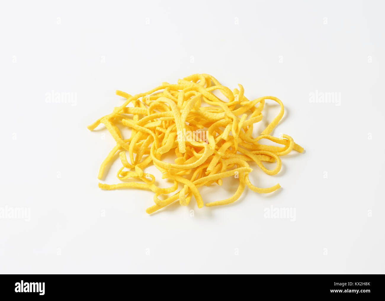 Heap of Dried Egg Noodles (Spaetzle) on white background Stock Photo
