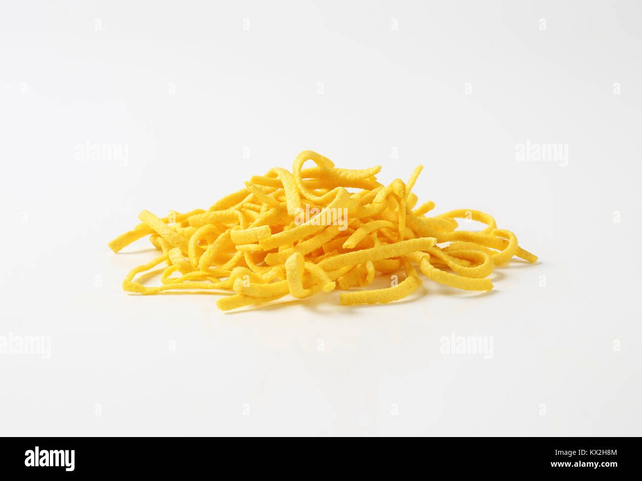 Heap of Dried Egg Noodles (Spaetzle) on white background Stock Photo