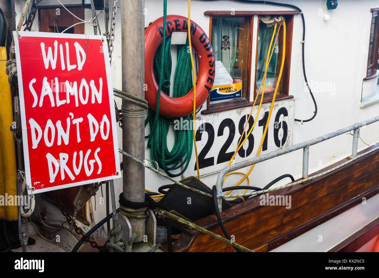 Sign pointing to the benefits of eating wild Salmon and not buying farmed Salmon Stock Photo