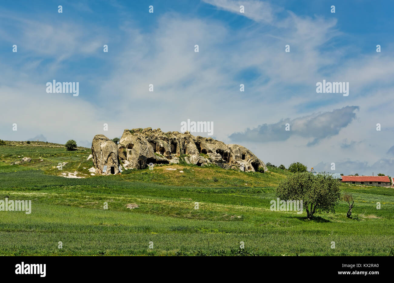 Green landscape with a beautiful rock formation under blue skies with ...