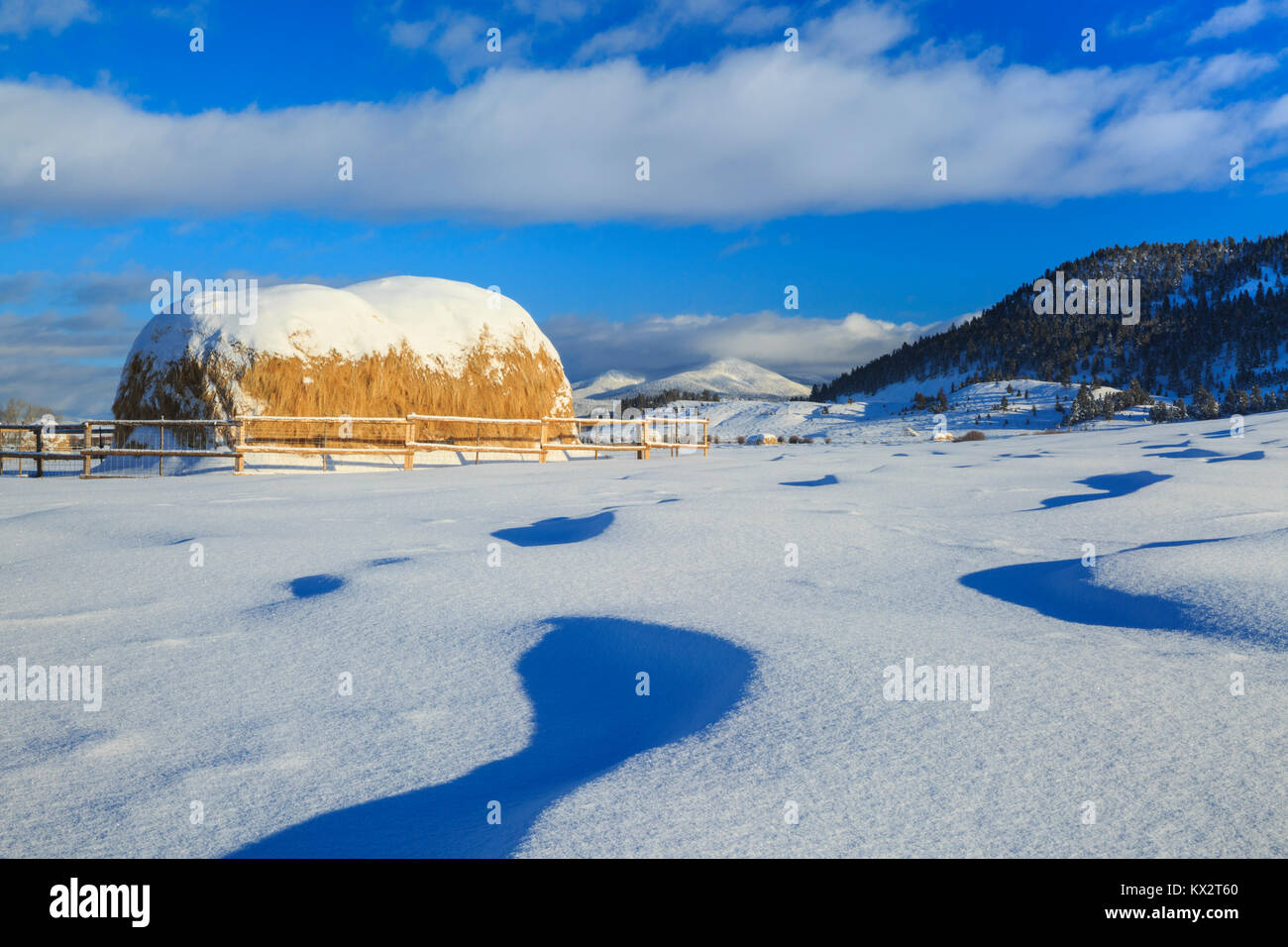 haystacks and snow drifts below the continental divide near avon, montana Stock Photo