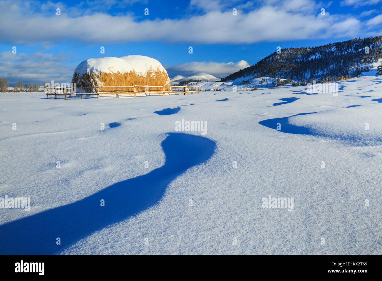 haystacks and snow drifts below the continental divide near avon, montana Stock Photo