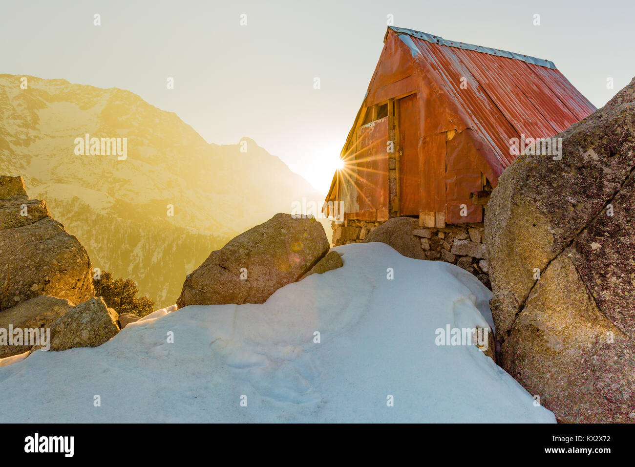 Serene and beautiful Cabin in the snow mountains at Triund hill top, Mcleod ganj, Dharamsala, India during amazing sunrise from behind the mountain Stock Photo