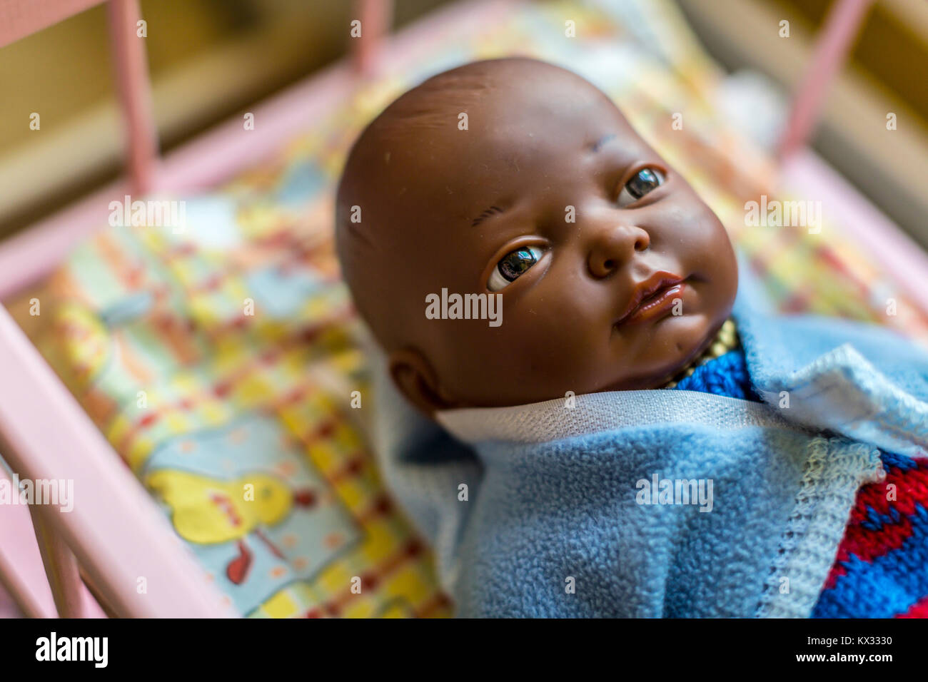 Dark skin baby doll dressed in blue Stock Photo