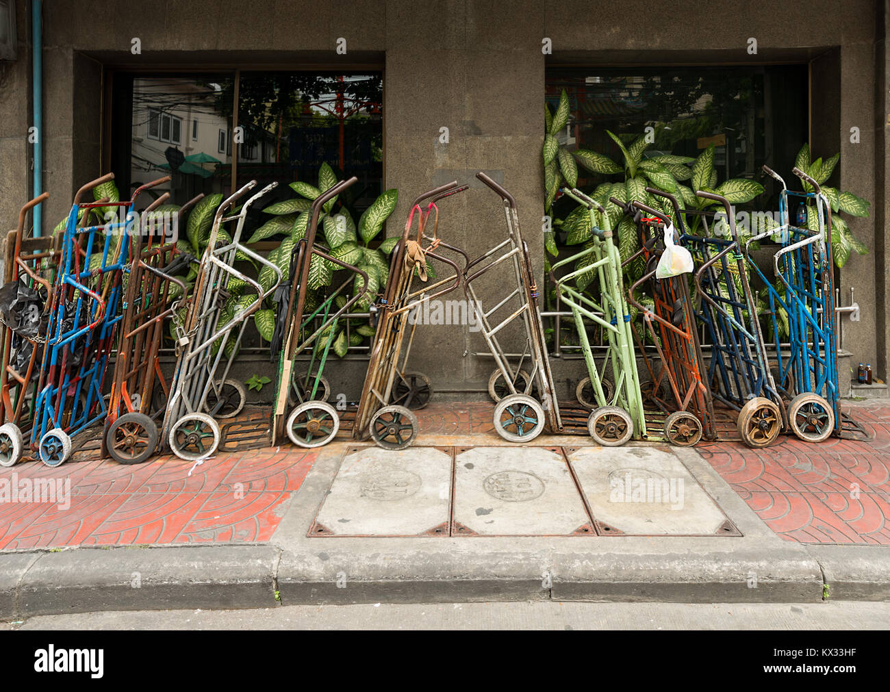 Many potters sack trucks neatly lined in a Bangkok city side street