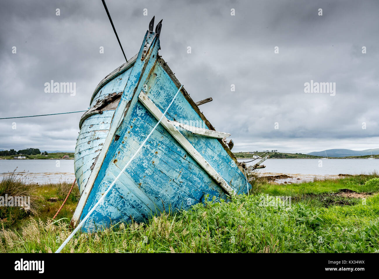 The prow of the wreck of an old blue wooden fishing boat stranded on ...