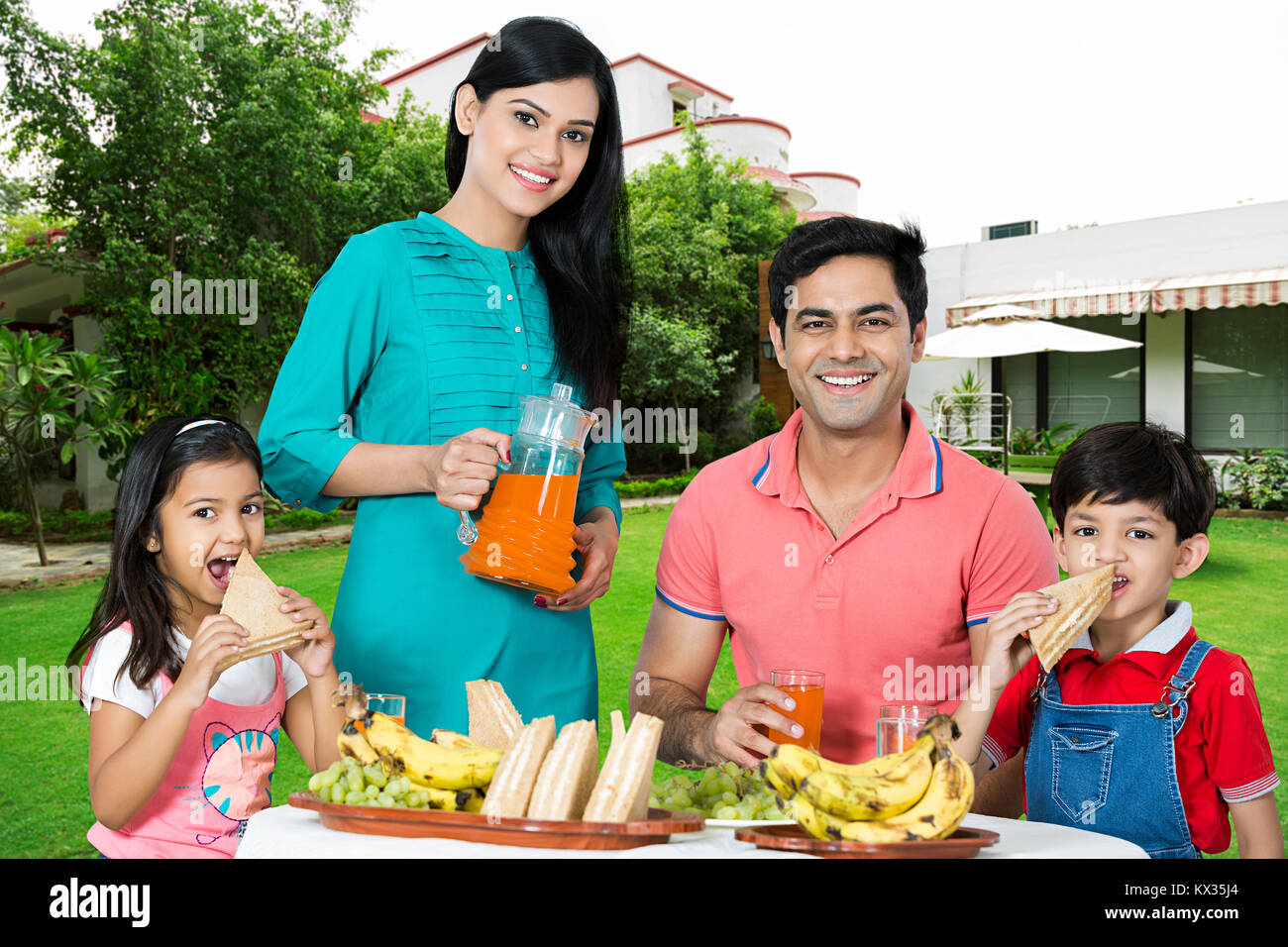 Happy Family parents and Children eating breakfast together Courtyard at-home Stock Photo