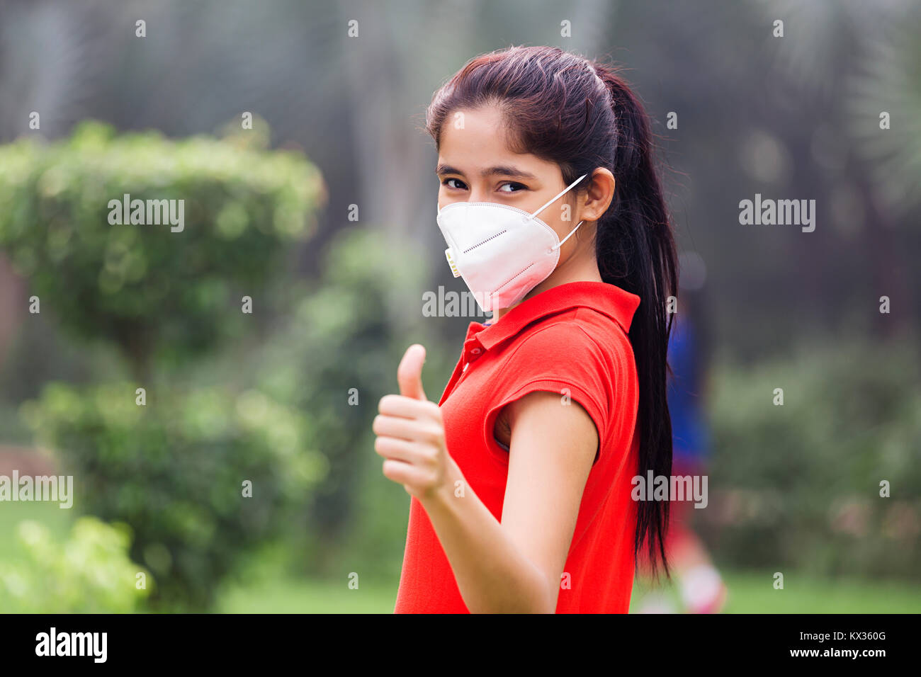 Young Girl Face Air Pollution Problem In Park Stock Photo