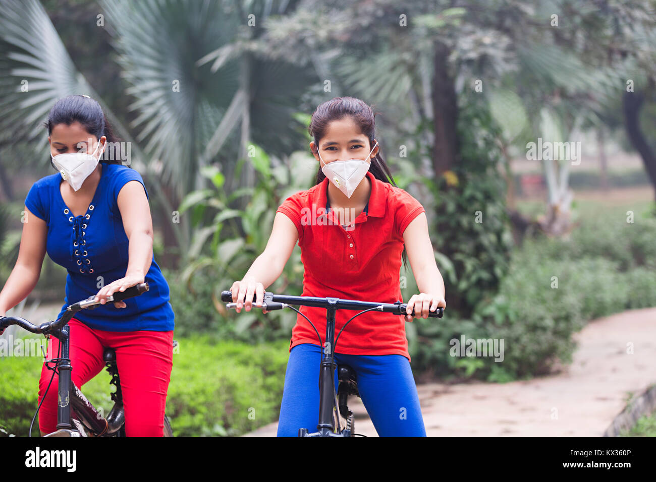 Young Girls Riding Cycle Park Garden Stock Photo - Alamy