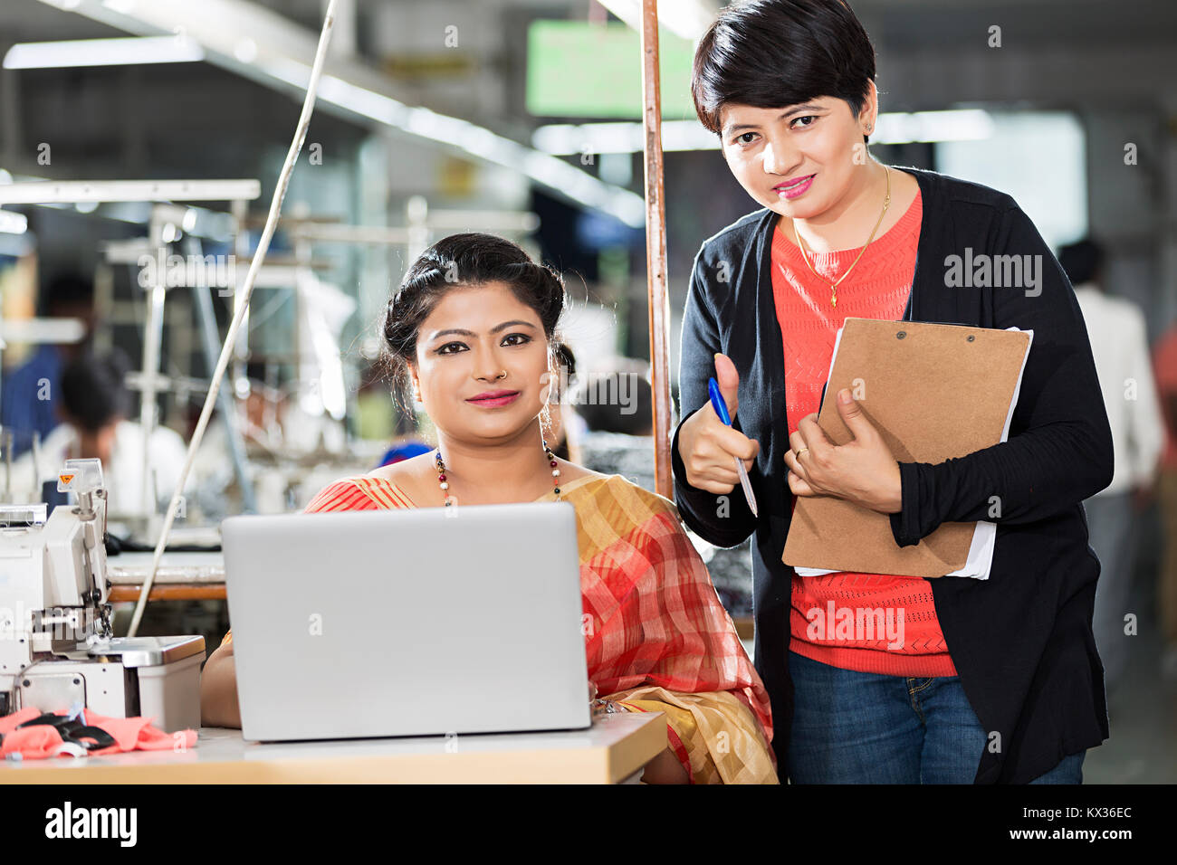 Woman Worker Tailor and Supervisor Using Laptop Working Discussing Garment-factory Stock Photo