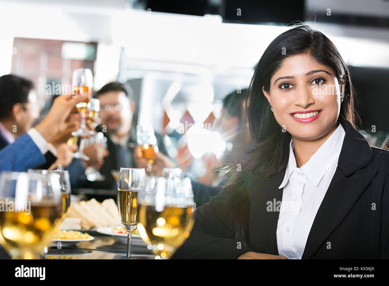 Indian Business Female sitting dining table With Partners Company- Party Restaurant Stock Photo