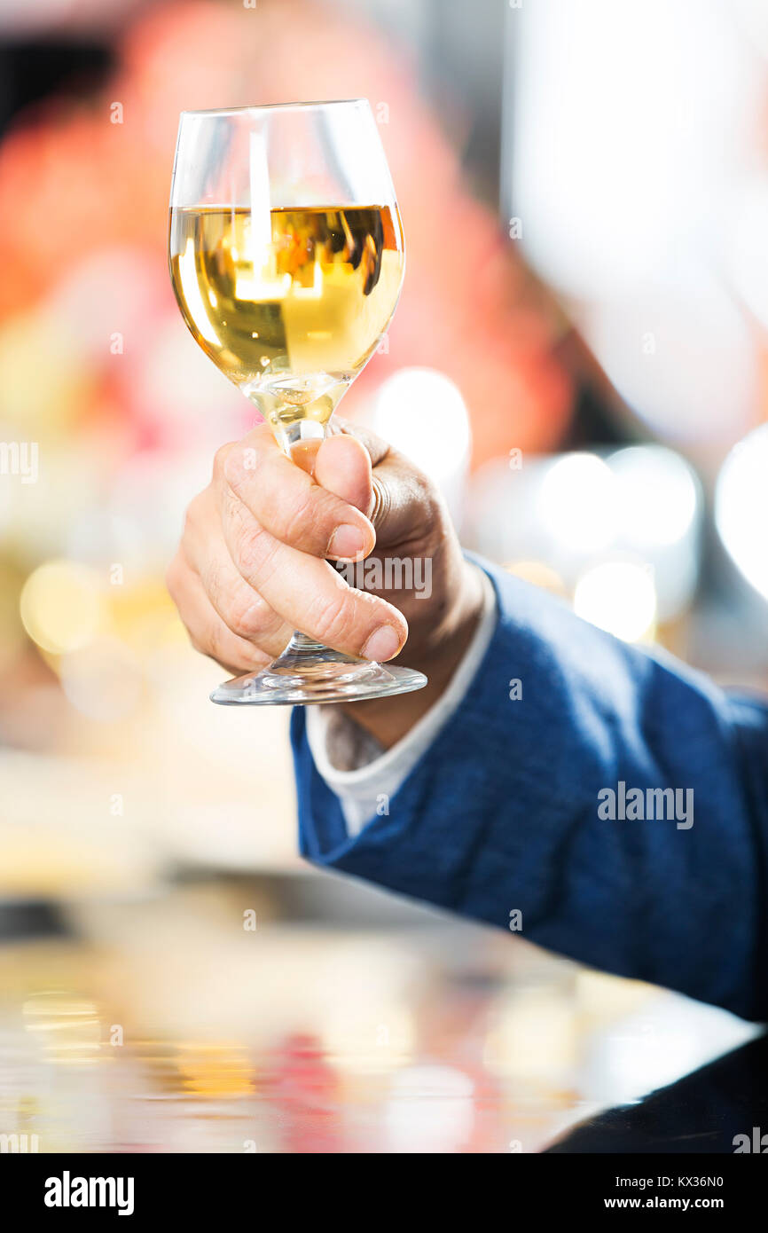 Part-Of Adult male hand Holding Champagne Glass Celebrating Party In Bar Stock Photo