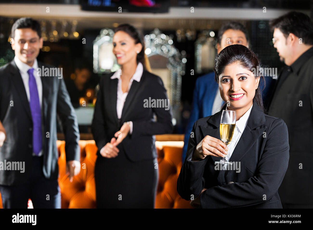 Business Female Drinking Alcohol with colleagues In-the-Background Enjoy Party Restaurant Stock Photo