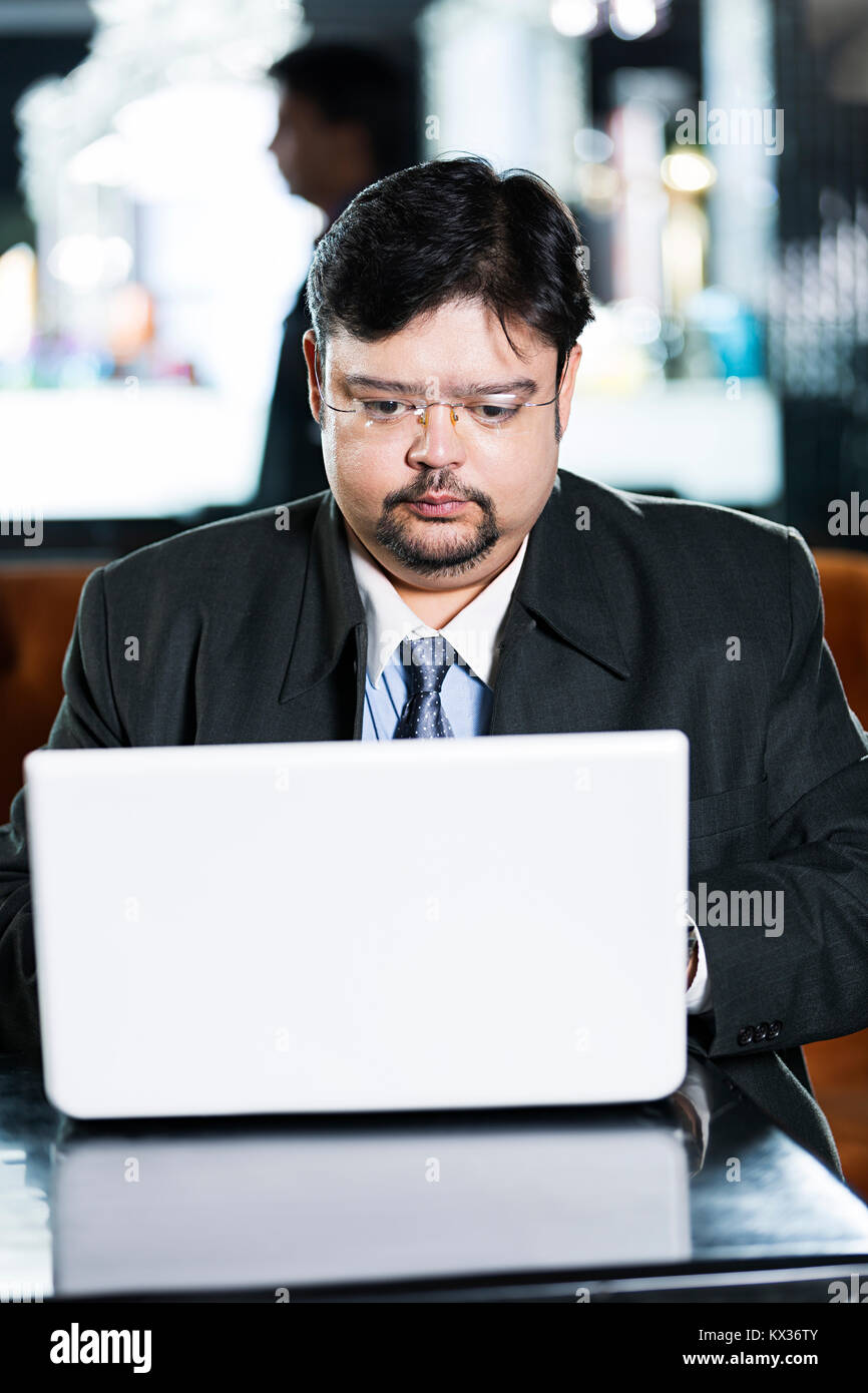 1 Business man Sitting On Table Using Laptop Working In-Office Stock Photo