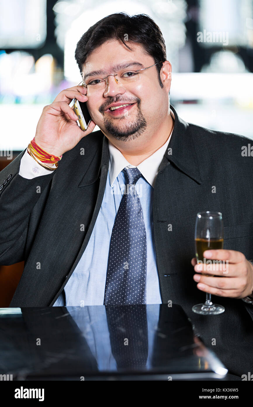 One Business man Talking On Mobilephone And Drinking Champagne In-Restaurant Stock Photo