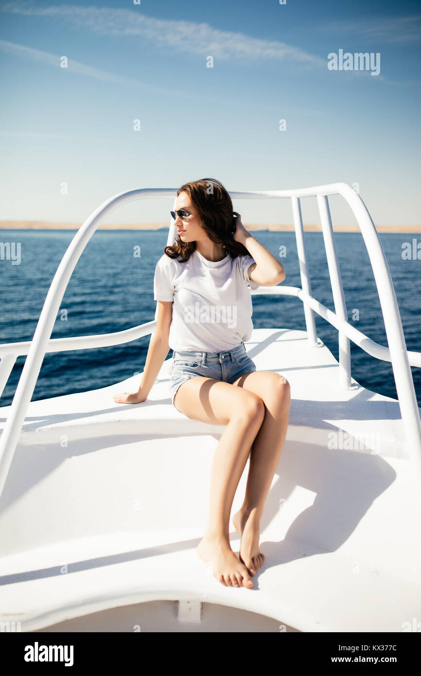 Young woman in summer outfit sitting at deck of yacht and looking away with  sea Stock Photo - Alamy