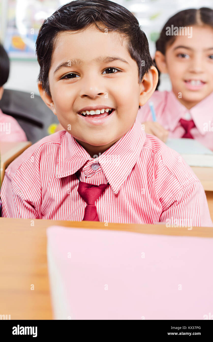 Indian School Little Boy Sitting In Classroom Smiling Stock Photo