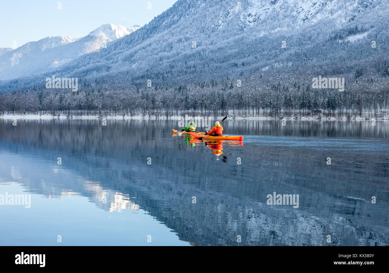 two people kayaking in the winter among mountains Stock Photo
