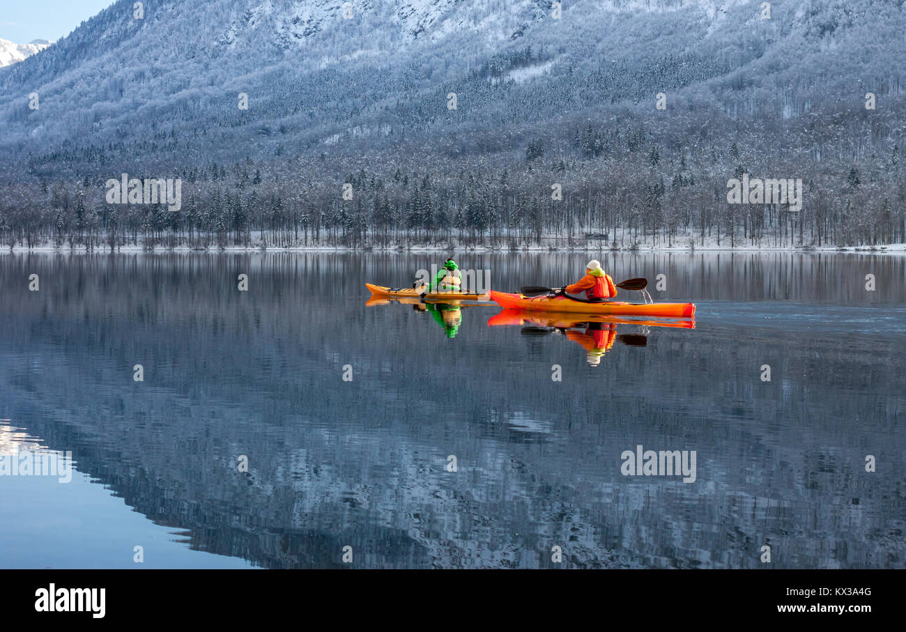 two people kayaking in the winter among mountains Stock Photo
