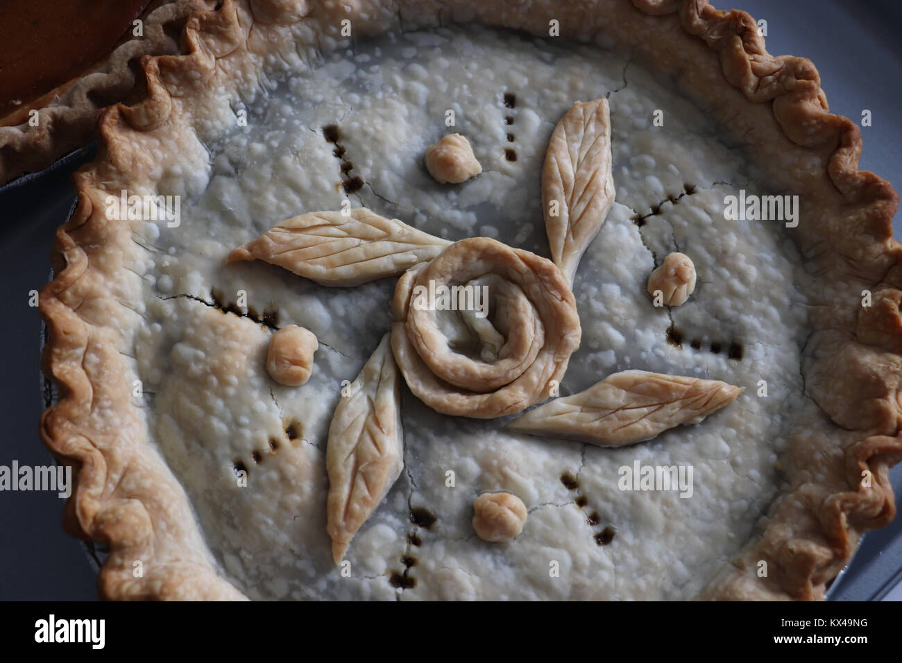 Traditional mincemeat pie with fancy crust and decoration prepared for the Christmas holiday meal.  Rose pattern formed from piecrust, and fluted edge. Stock Photo