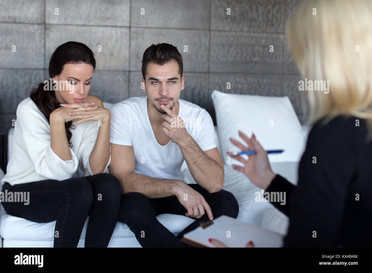 Young couple at consulatant therapist solving problems, bored man Stock Photo