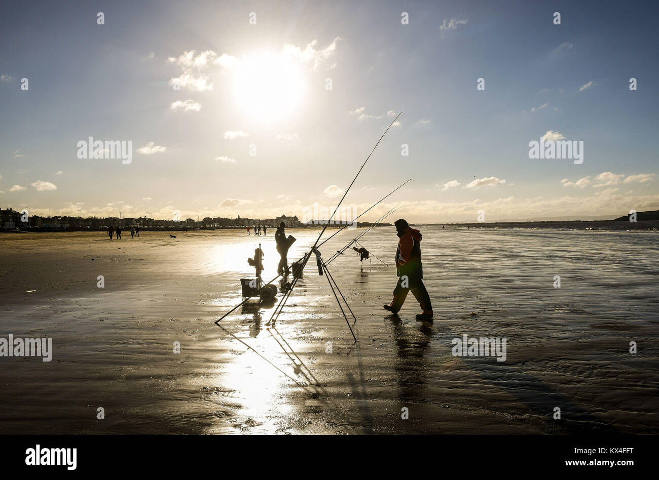 Fishermen return to their rods and reels on Weston-super-Mare Beach, Somerset, as temperatures plummet across the UK. Stock Photo