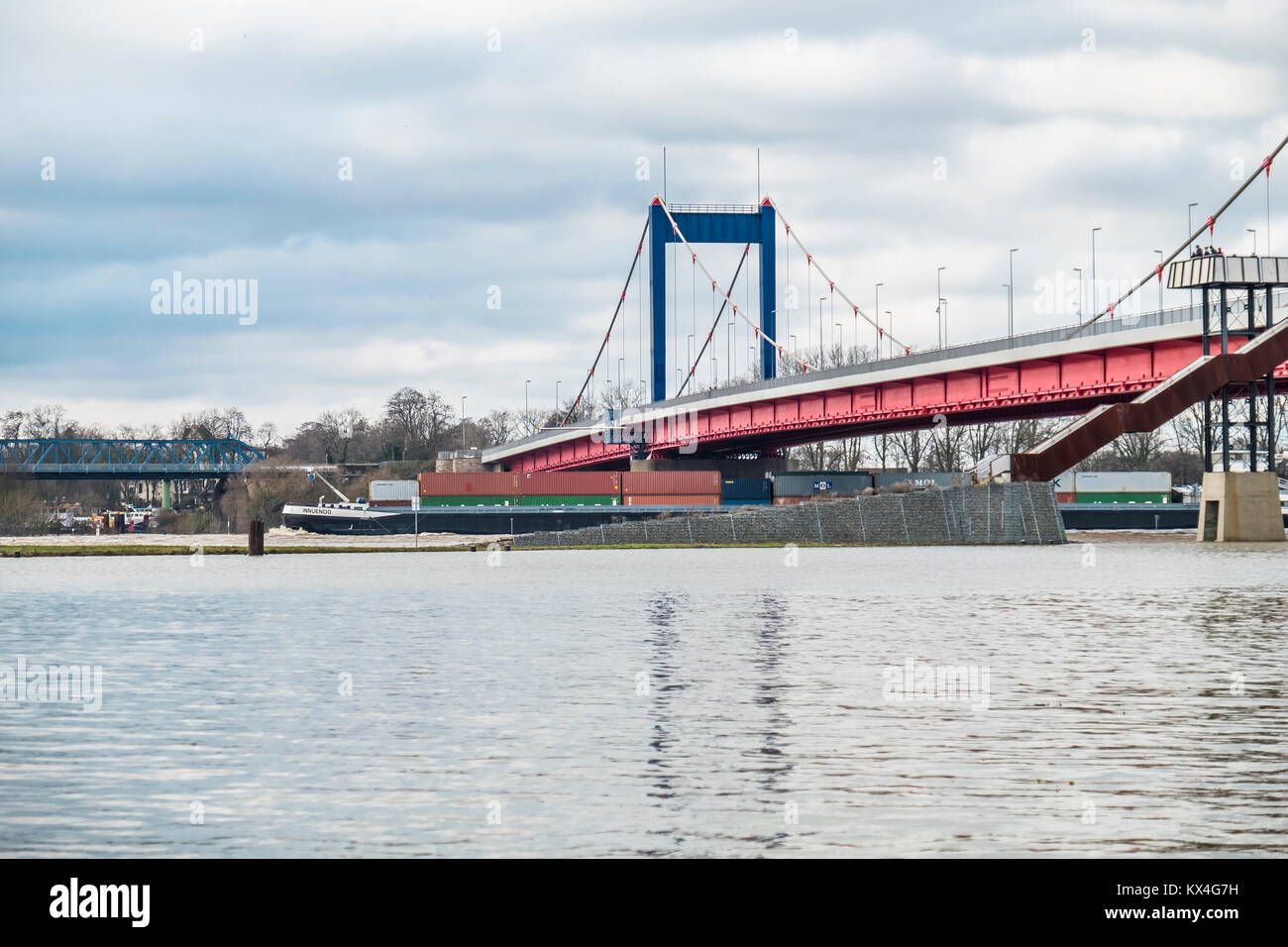 DUISBURG / GERMANY - JANUARY 08 2017 : Container ship is passing the bridge in Ruhrort during the flooding Stock Photo