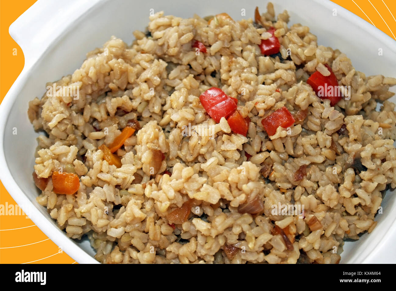 Cooked wholegrain brown rice with peppers in a casserole dish Stock Photo