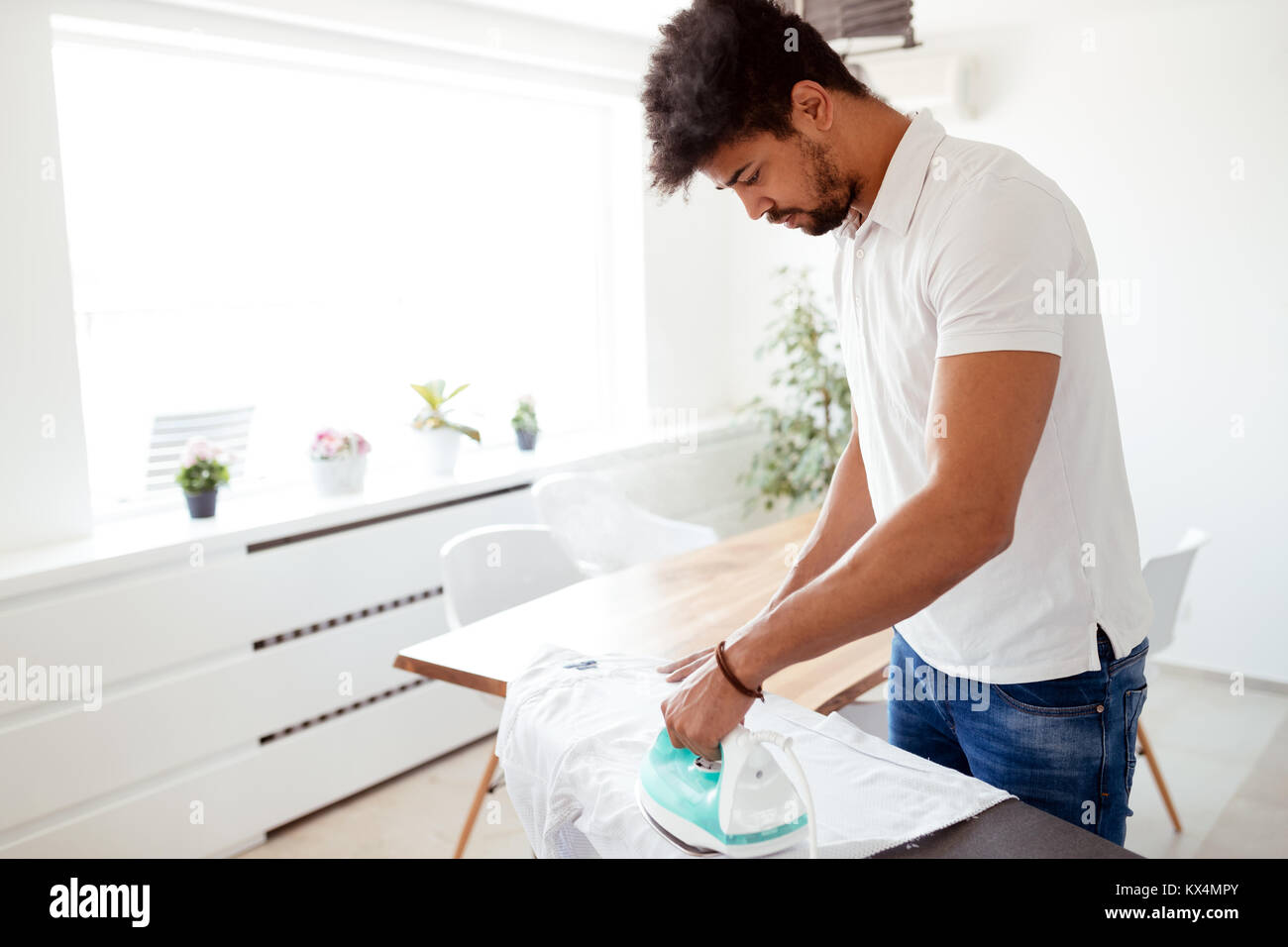Man ironing shirt on ironing board Stock Photo