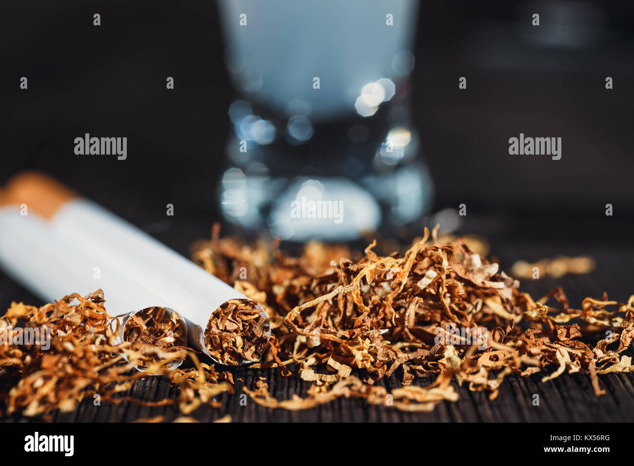 hand made cigarette and tobacco with a glass of vodka in the background  Stock Photo