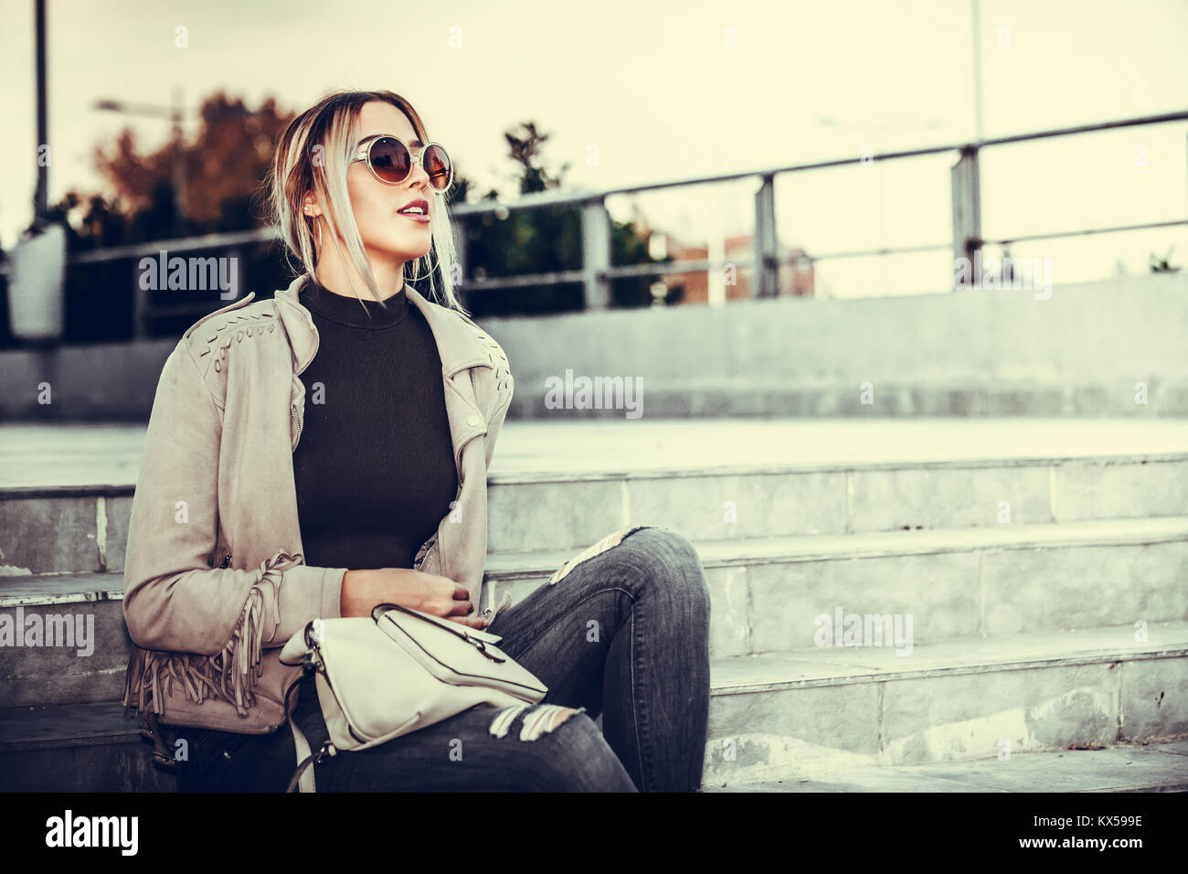 Portrait of a beautiful young modern and urban woman outside with ...
