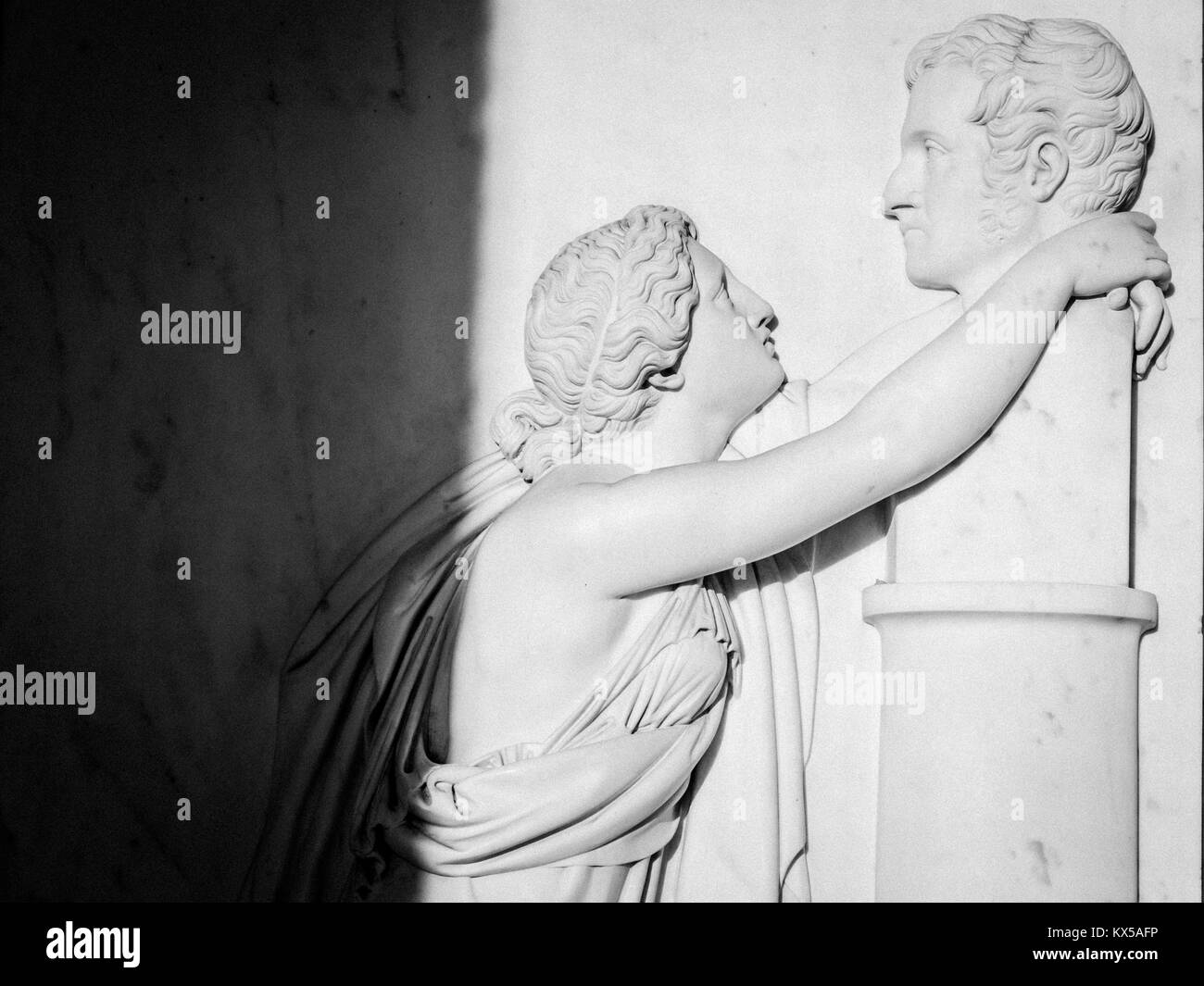 Bas relief of an ancient woman (roman or greek) hugs a man's bust. Really intense image Stock Photo