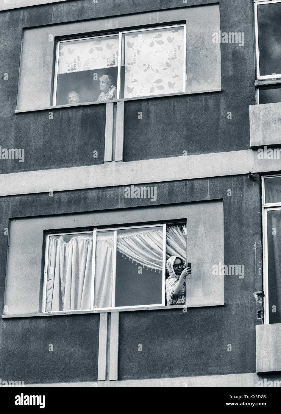 Woman with mobile phone leaning out of window in Spain. Coronavirus, self isolstion, social distancing, quarantine... concept Stock Photo