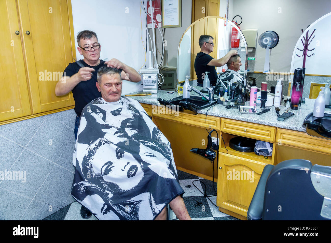 Coimbra Portugal,historic center,neighborhood,barber shop,haircut,cape,mirror,reflection,interior inside inside,working,Hispanic,immigrant immigrants, Stock Photo