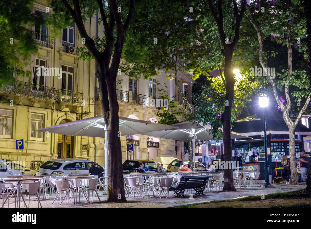 Lisbon Portugal,Avenida da Liberdade,promenade,Bananacafe,al fresco,sidewalk outside outdoors tables dining street,tables,umbrellas,evening,lighting,t Stock Photo