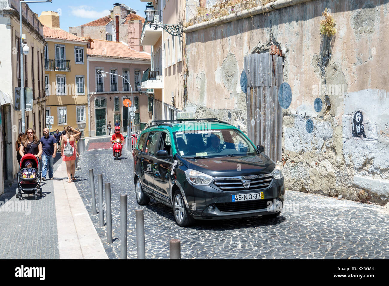 Lisbon Portugal,Castelo quarter,Costa do Castelo,inclined,uphill,sidewalk,taxi,woman female women,stroller,pedestrian,walking,cobblestone,Hispanic,imm Stock Photo