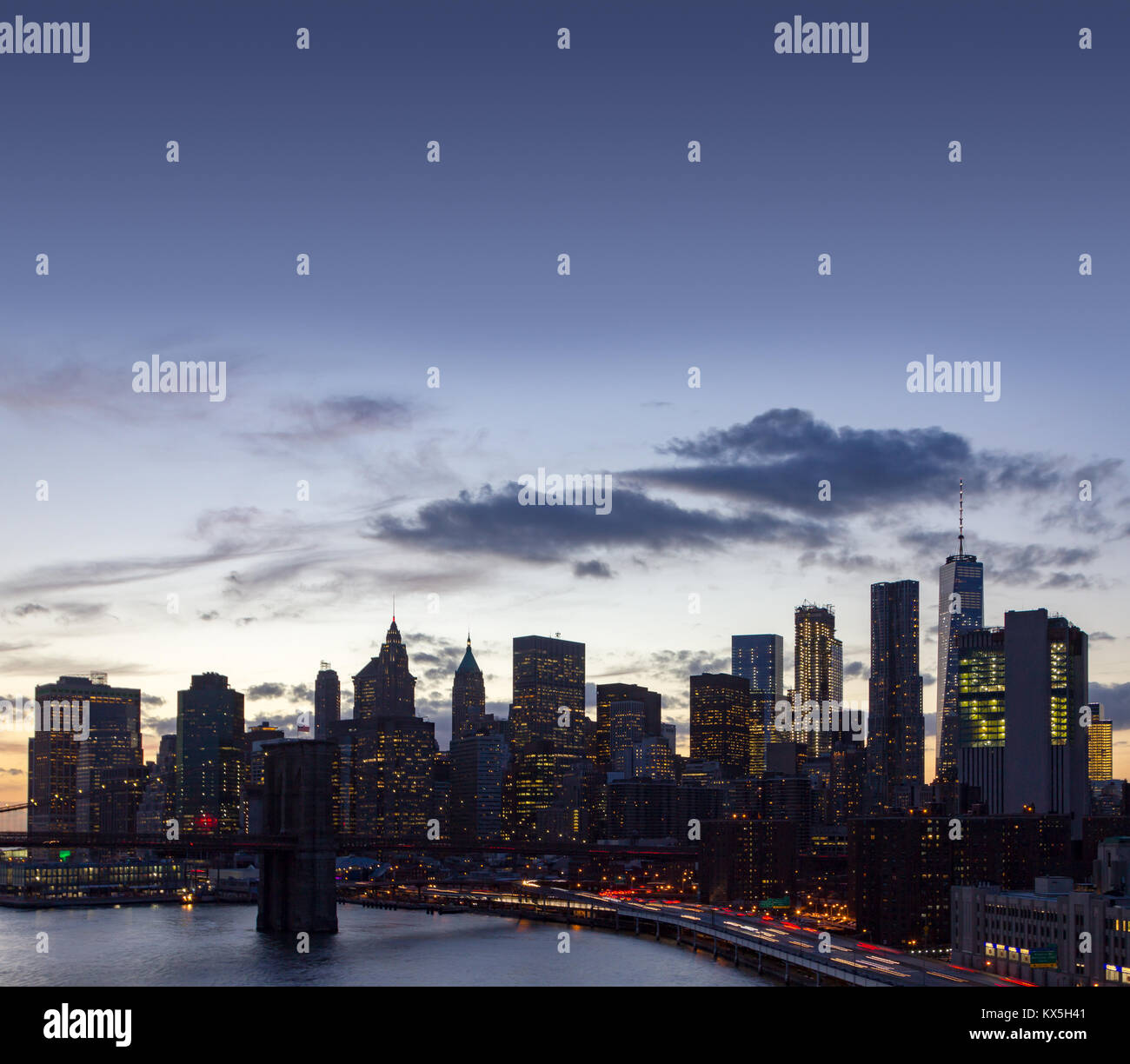 New York City skyline lights at dusk with the Brooklyn Bridge and ...