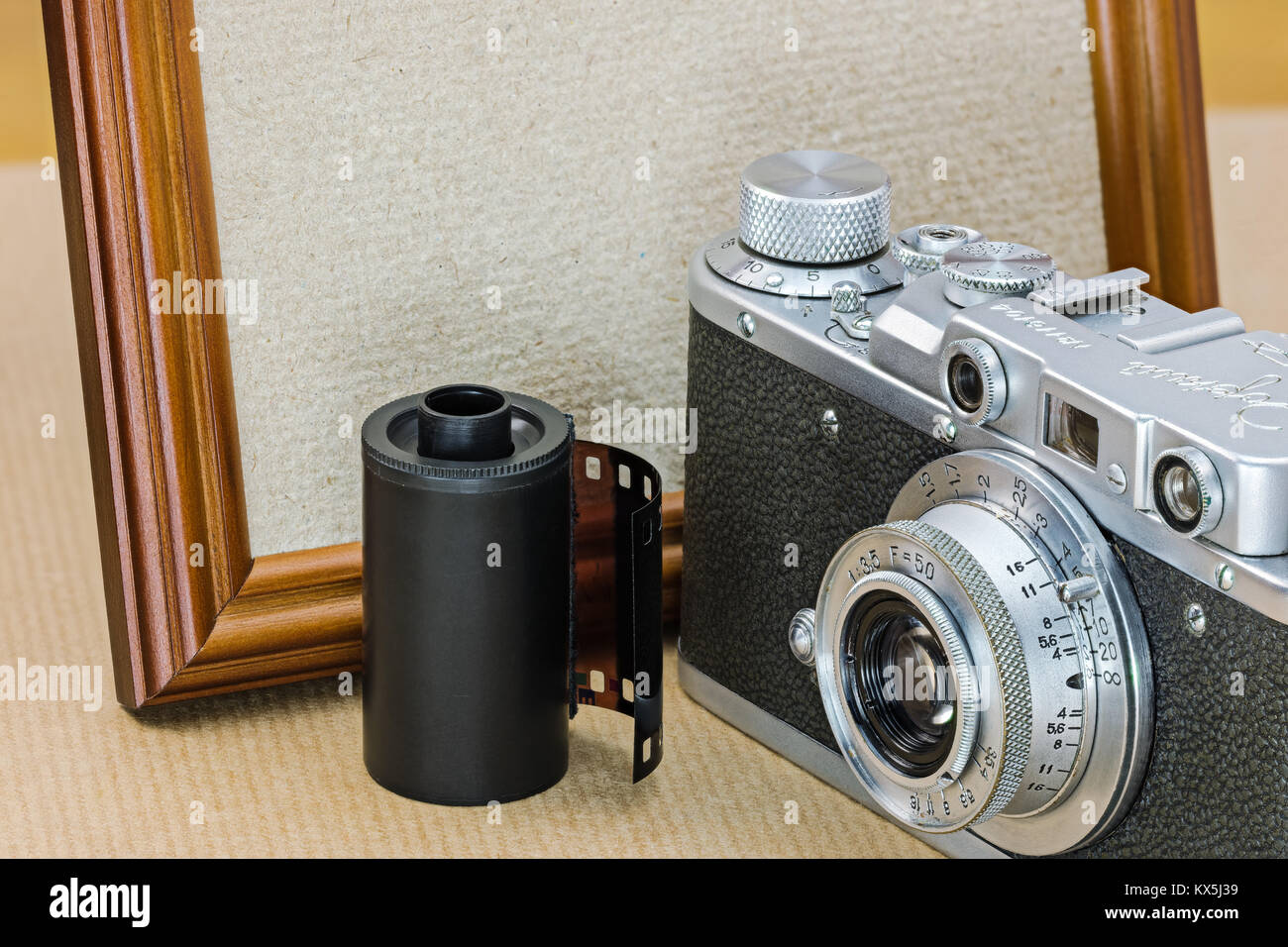 retro camera, film roll and empty wooden photo frame in vintage style macro view Stock Photo