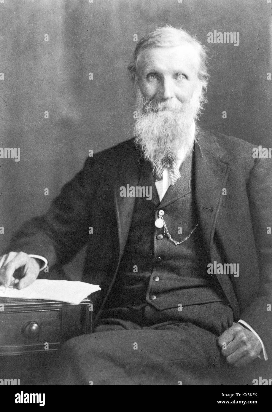 John Muir,1838-1914,Scottish American naturalist,author,seated on rock,lake,tree