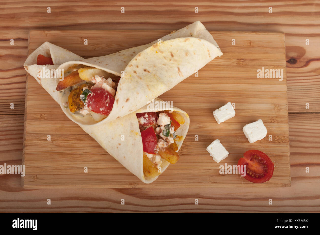 Tortilla wraps with chicken meat, tomato, french fries and feta cheese, traditional greek fast