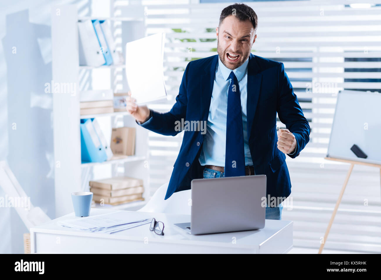 Furious businessman expressing anger while standing in his office Stock Photo